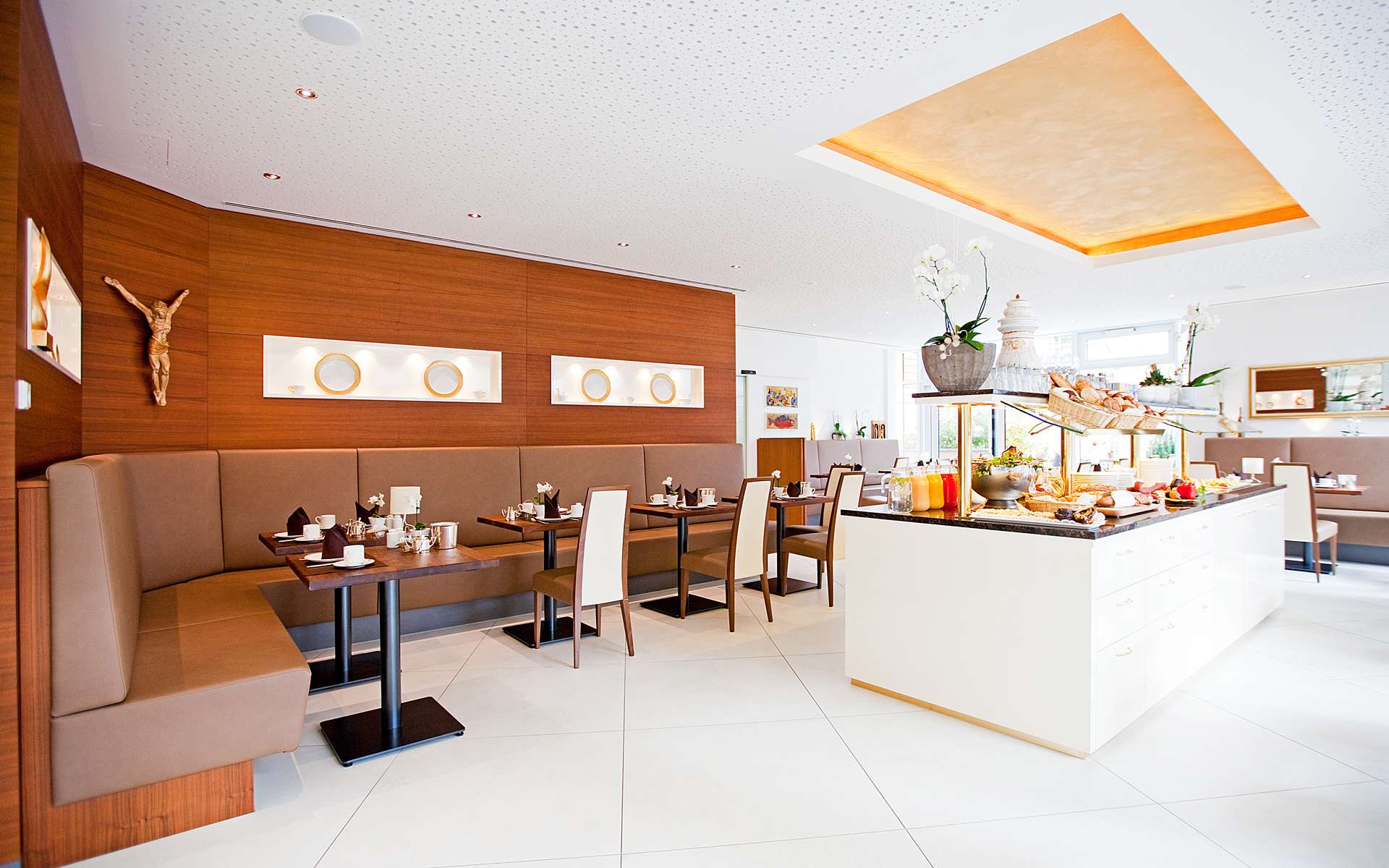 Frühstücksraum mit Holzwand, Sitzbänken und Buffet