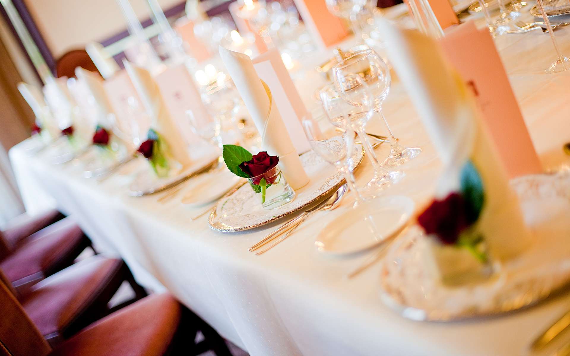 Festlich gedeckte Tafel mit Rosen und Weingläsern