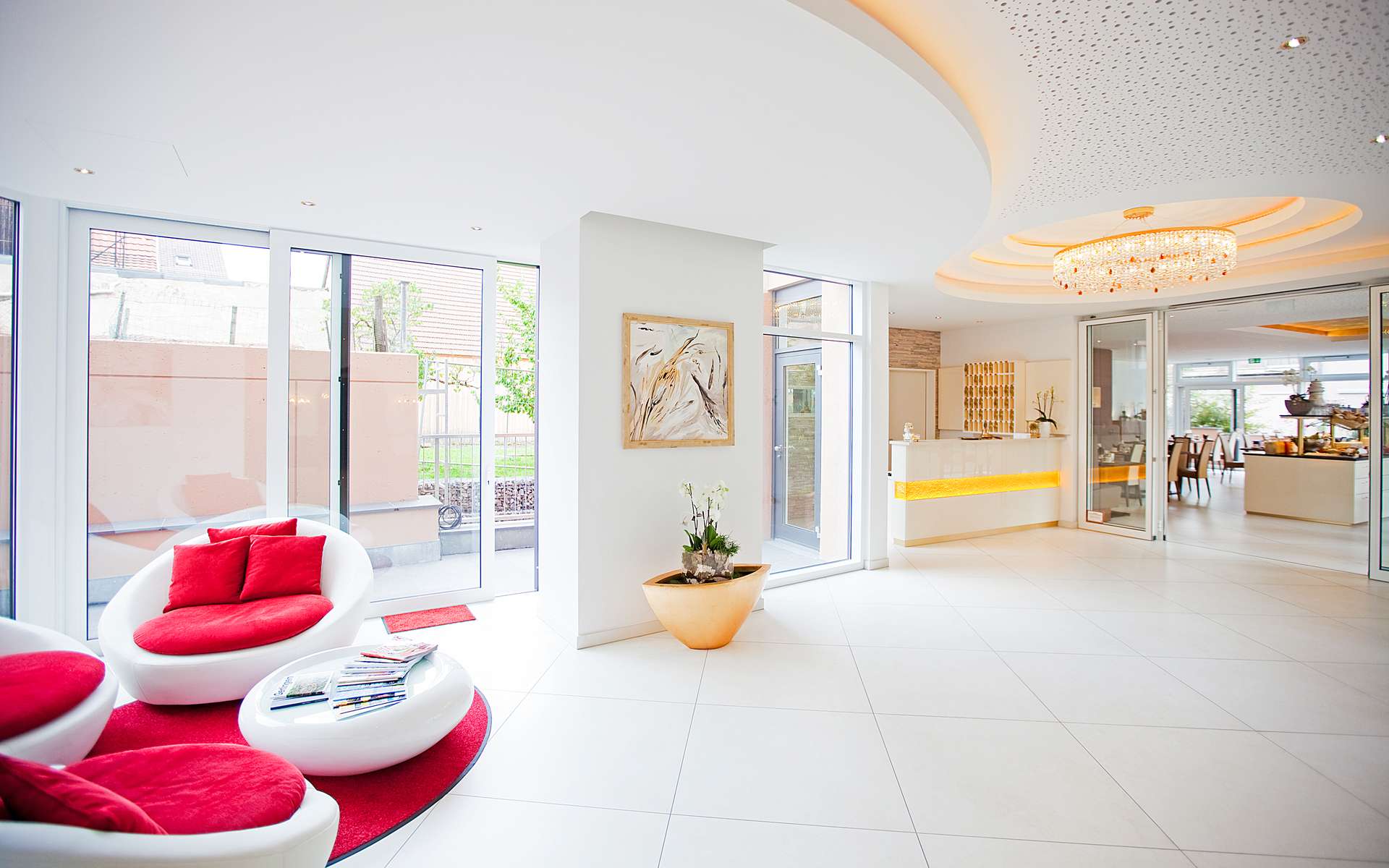 Lobby mit roten Loungesesseln und Blick zur Rezeption